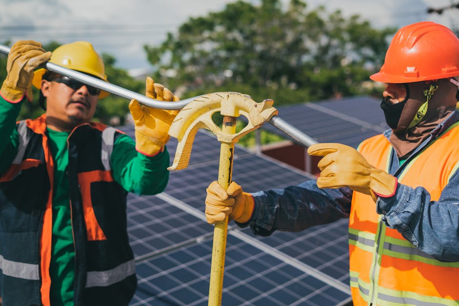 Two construction workers assembling solar panel equipment under sunny conditions, showcasing teamwork and renewable ener